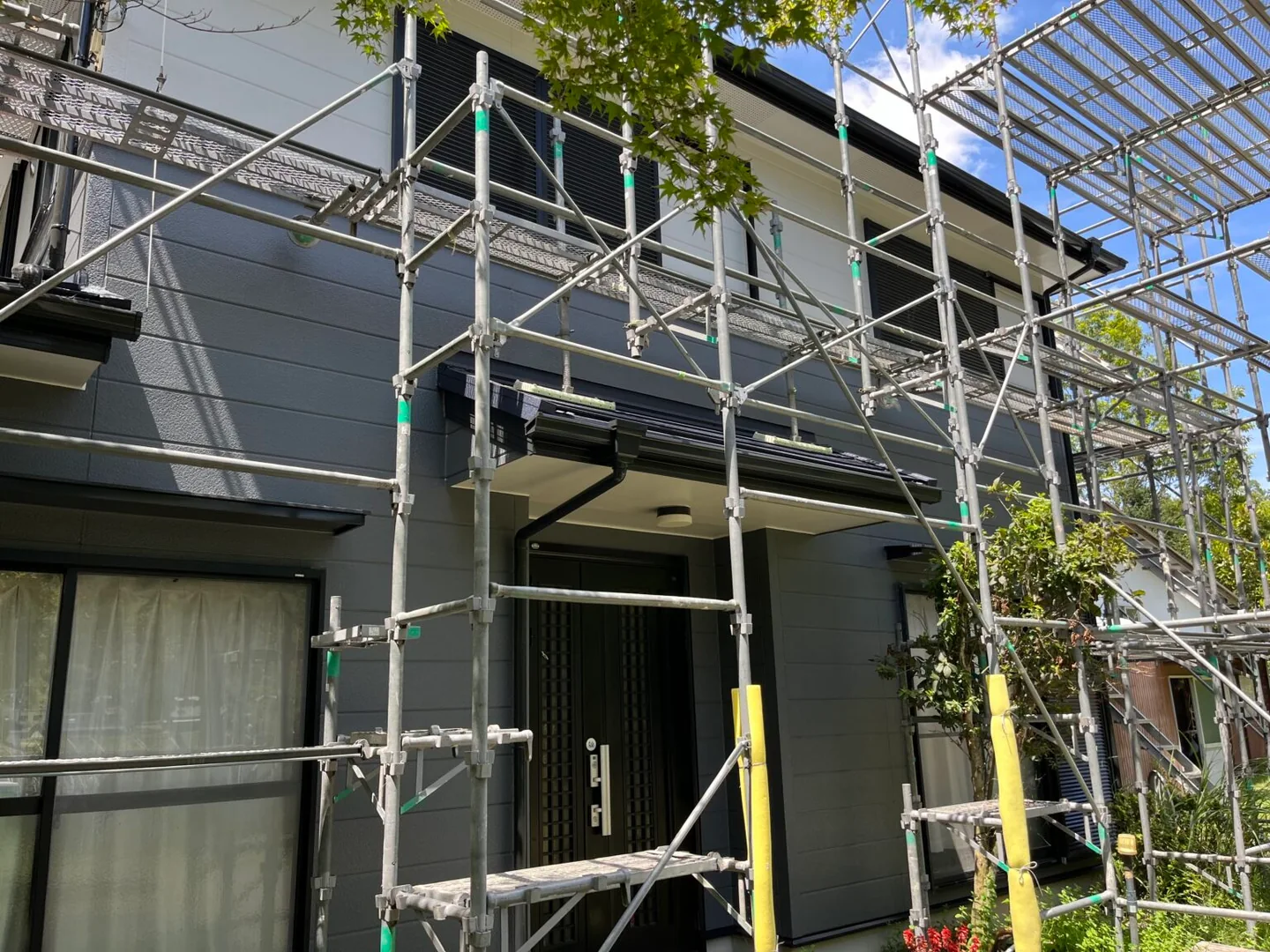 京都府南山城村の実際の施工住宅。外壁塗装後、足場撤去前の玄関側の仕上がり